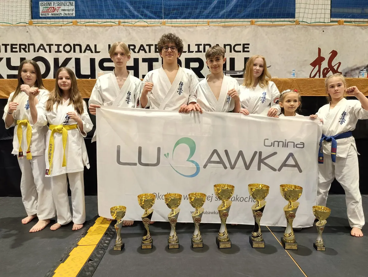 Drużyna Fight Club Lubawka z pucharami i banerem Gminy Lubawka na Mistrzostwach Europy juniorów IKA